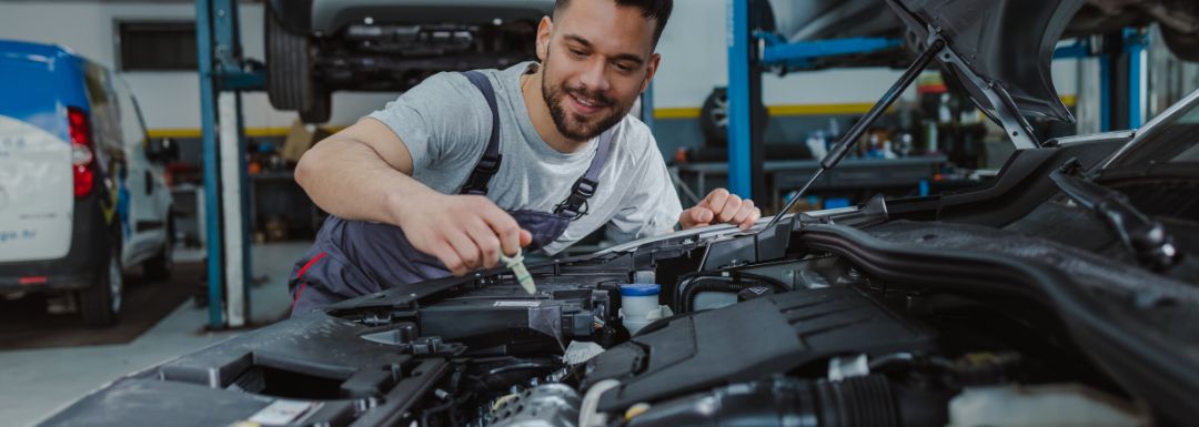 Automotive technician inspecting a vehicle for specialized repair services.