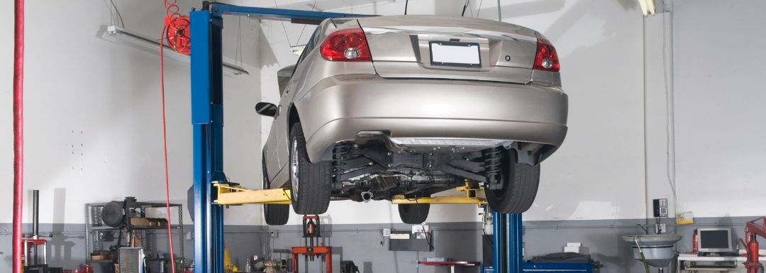 Car on hydraulic lift in auto repair shop at auto repair