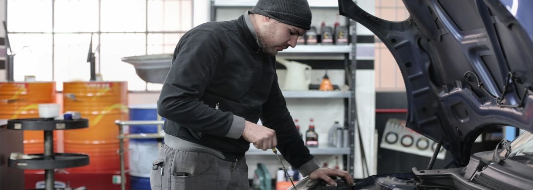 hudsonville auto repair. Mechanic performing engine maintenance under car hood