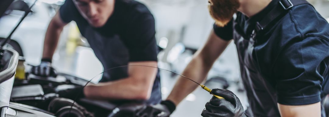 transmission is slipping. Technicians checking transmission fluid to diagnose transmission slipping issues