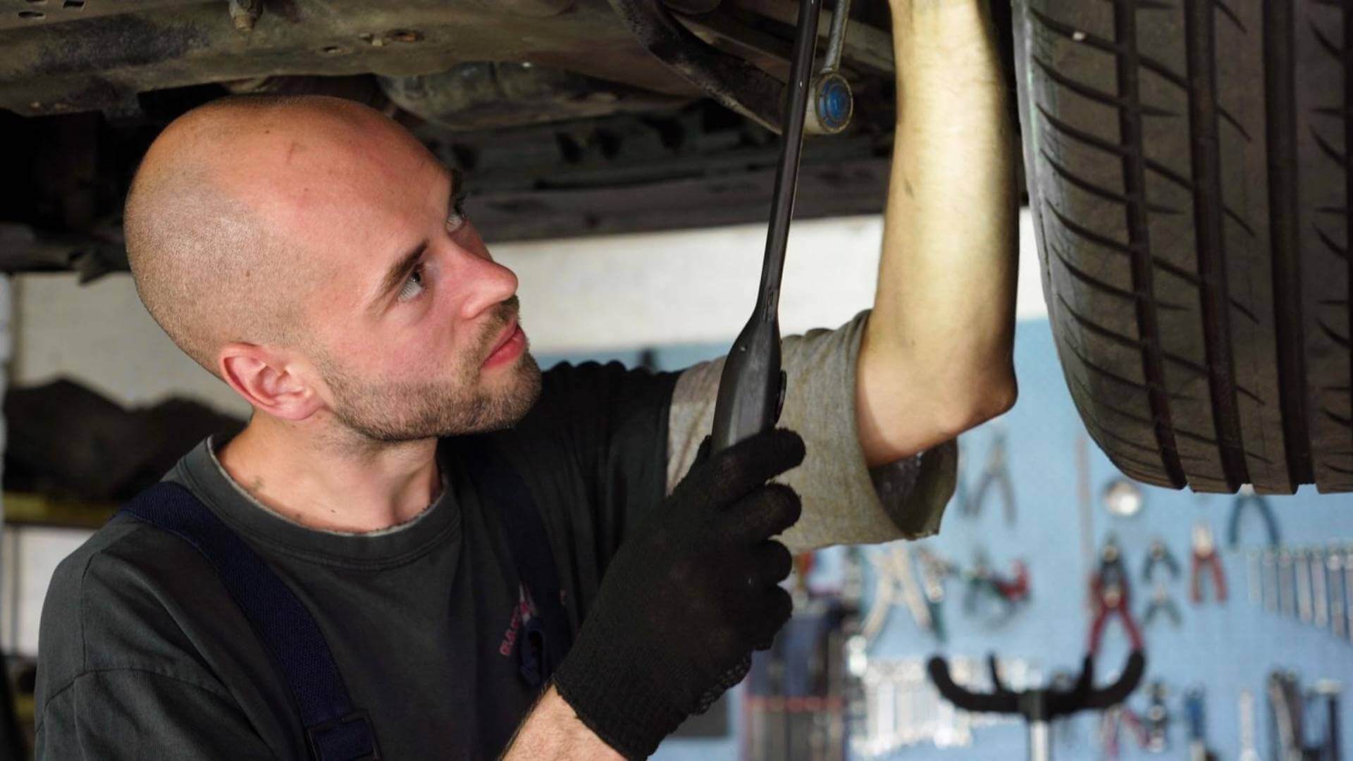GM 6L80 transmission problems mechanic inspecting transmission under vehicle