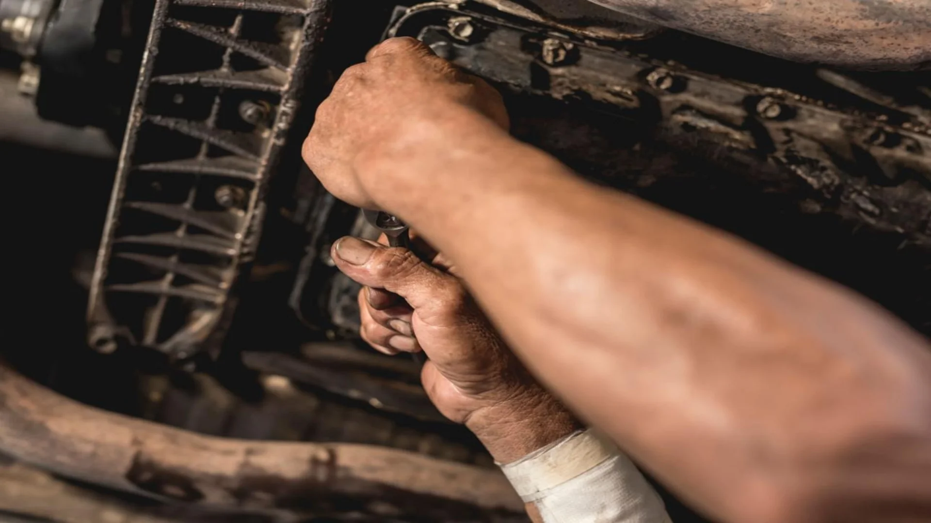 transmission leak under car mechanic inspecting transmission pan leak